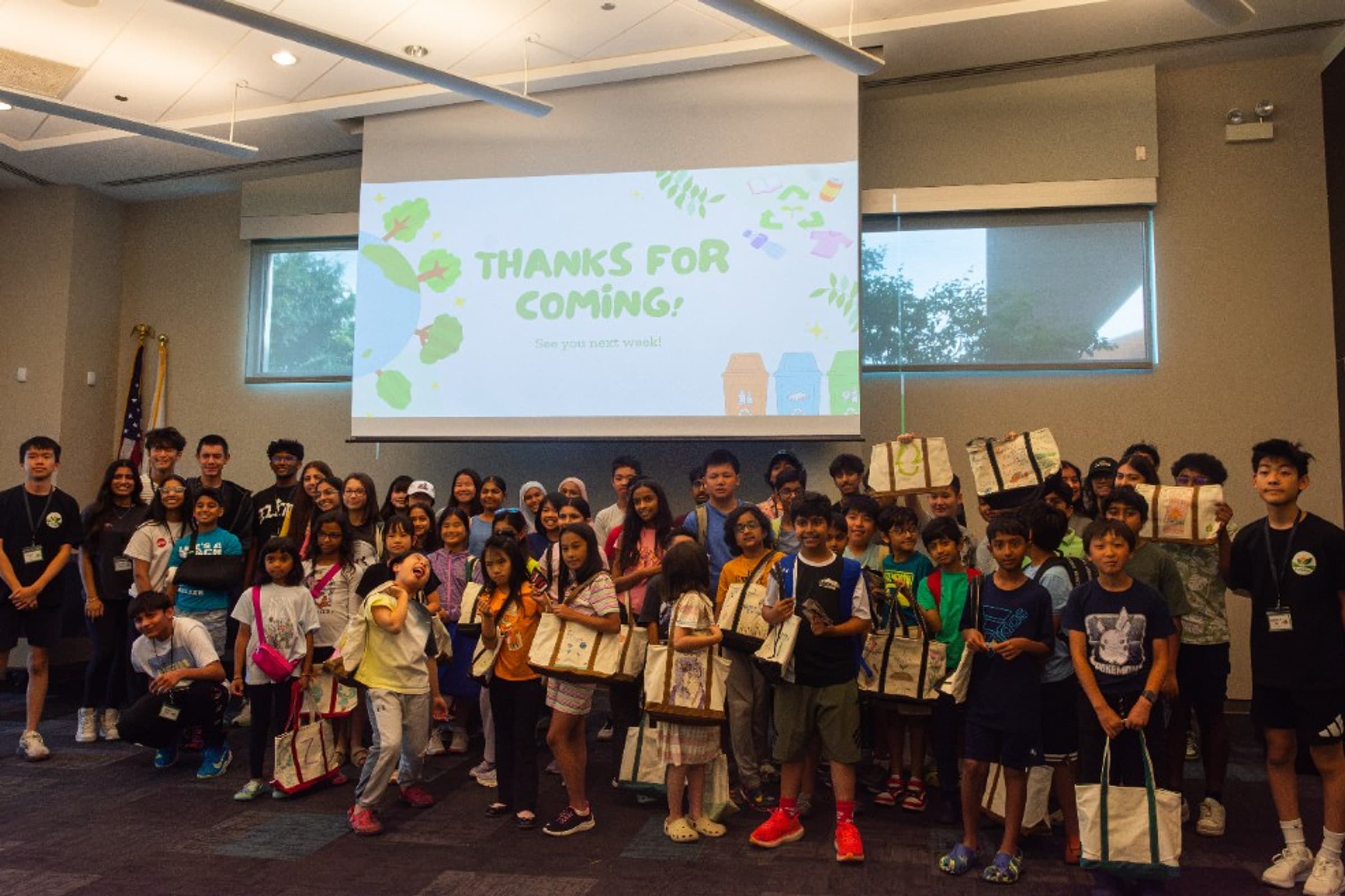 EcoRise students in a classroom with a presentation screen displaying Thanks For Coming
